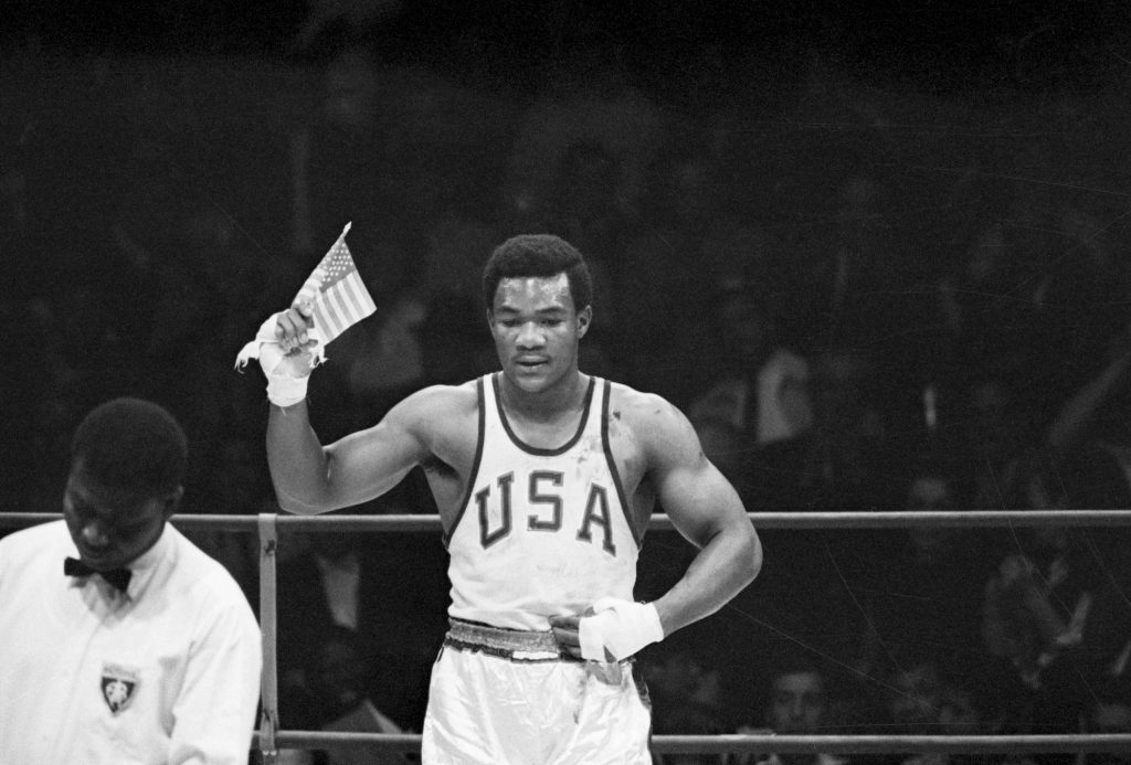 US-Fähnchen statt „Black Power“-Geste – George Foremans Verhalten nach seinem Olympiasieg 1968 kommt nicht bei allen Amerikanern gut an. (Foto: Getty Images)