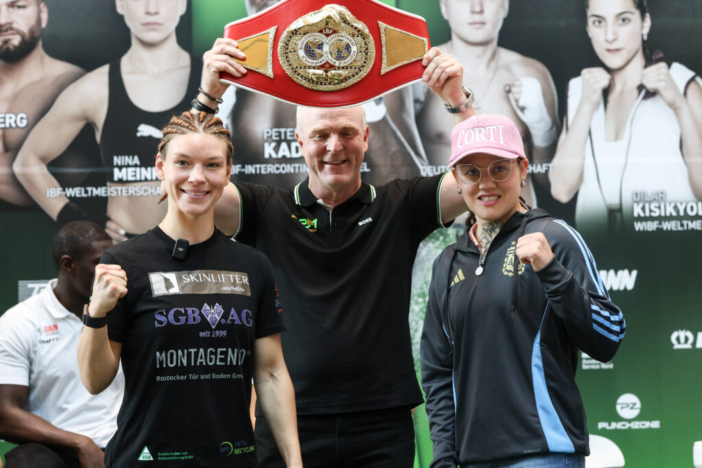 Nina Meinke (l.), Daniela Bermudez (r.) und das Objekt der Begierde, um das es am Samstag bei „Hamburg Boxt“ gehen wird: den IBF-Gürtel im Federgewicht, hier präsentiert von P2M-Promoter Axel Plaß. (Foto: IMAGO / Torsten Helmke)